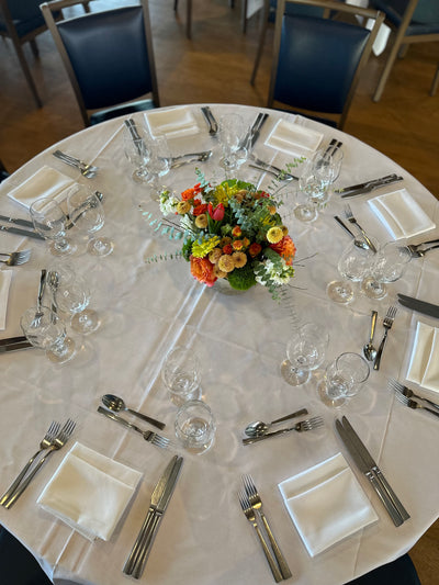 a centerpiece of seasonal flowers in warm tones