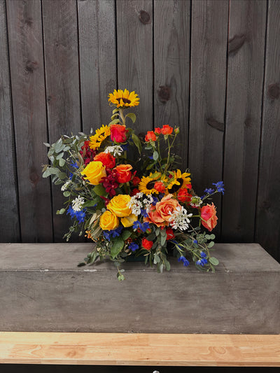 flower arrangment with sunflowers, delphinium, roses, carrot and lots of texture