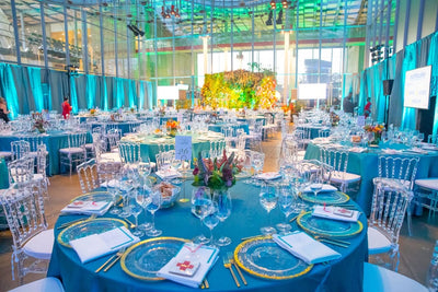 colorful under the sea setting for a rich gala event fundraiser.  blue tablecloths, golf chargers, colorful flowers