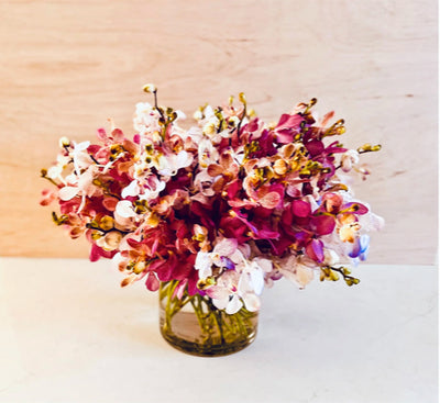 flower arrangement packed full of orchids in mass. crazy gorgeous modern